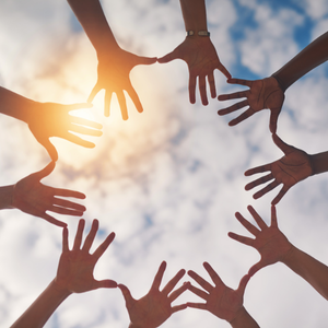 Symbolbild für Mit-einander mit mehreren Händen, die sich zu einem Kreis zusammenfinden